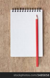 red pencils and notebook on a wooden background