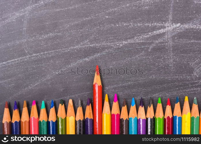 Red pencils color standing out from the crowd on blackboard and have chalkboard