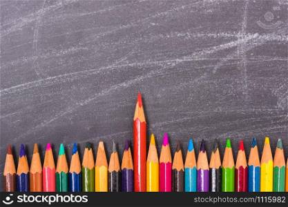 Red pencils color standing out from the crowd on blackboard and have chalkboard