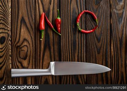 Red pepper NO word isolated on wooden background, top view. Organic vegetarian food, grocery assortment, natural eco products, healthy lifestyle concept. Red pepper NO word isolated on wooden background