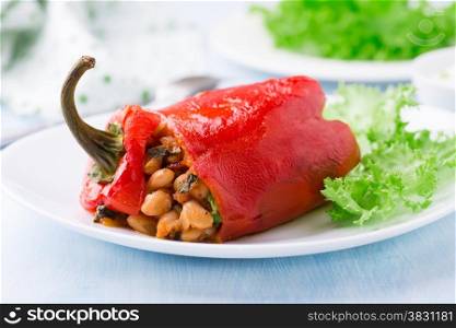 Red pepper stuffed with white beans on plate, close up, selective focus