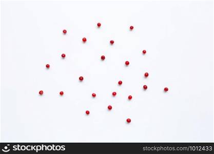 Red peppercorns on white background.