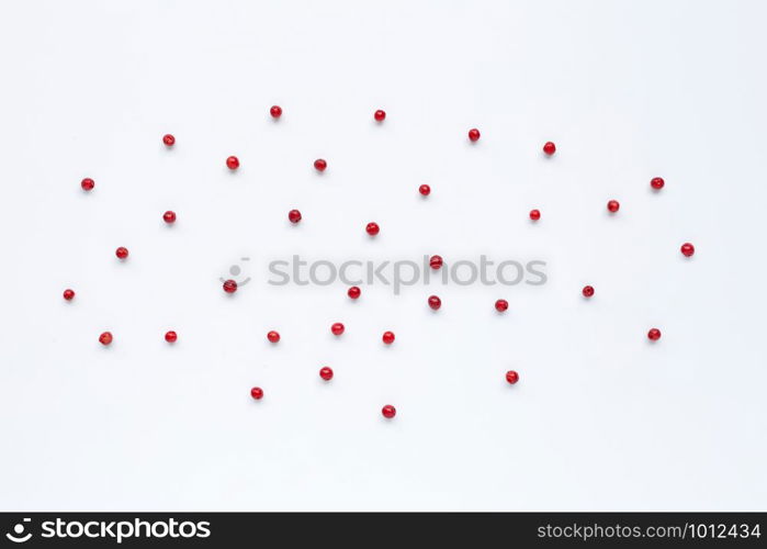 Red peppercorns on white background.