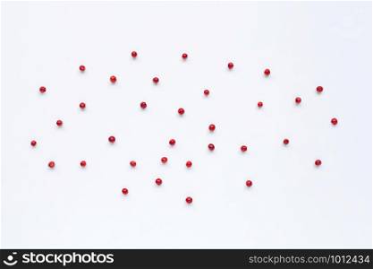 Red peppercorns on white background.