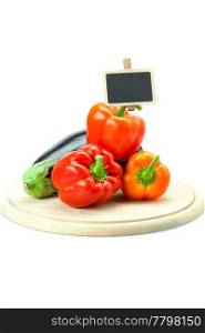 red peppers, eggplant and board on a cutting board isolated on white