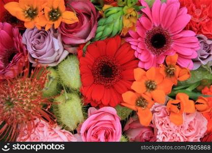 red, pink and orange flower arrangement with roses, gerberas and carnations