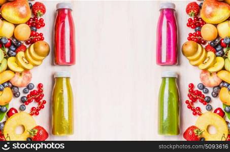 Red,pink,green and yellow smoothies and juices beverages in bottles with various fresh organic fruits and berries ingredients on white wooden background, top view. Healthy food concept