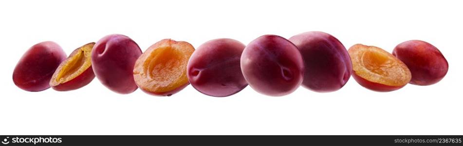 Red plums levitate on a white background.. Red plums levitate on a white background