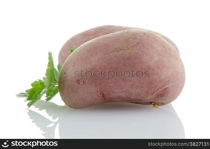 Red potatoes on white reflective background.