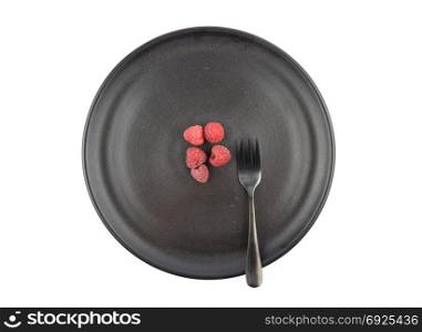 Red raspberries on plate and white