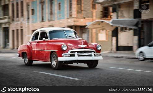 Red retro car on the street of Havana, Cuba, shot with panning