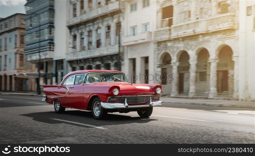 Red retro car on the street of Havana, Cuba, shot with panning