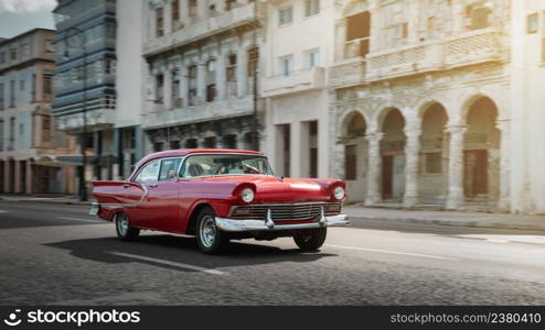 Red retro car on the street of Havana, Cuba, shot with panning