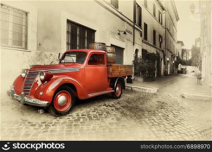 Red retro car on the street of Trastevere in Rome, Italy. Retro car sepia