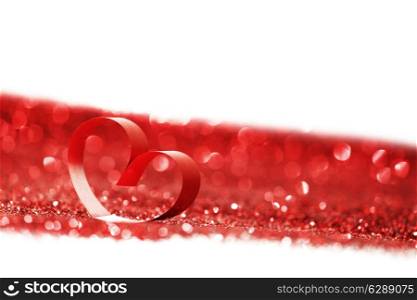 Red ribbon heart on glitters isolated on white, Valentines day concept