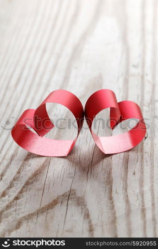 Red ribbon hearts on wooden background, Valentines day concept