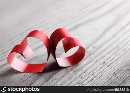 Red ribbon hearts on wooden background, Valentines day concept