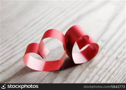 Red ribbon hearts on wooden background, Valentines day concept