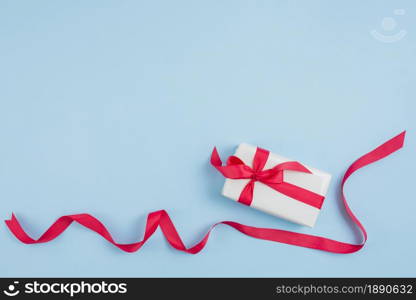 red ribbon near gift box . Resolution and high quality beautiful photo. red ribbon near gift box . High quality and resolution beautiful photo concept