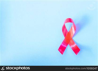 Red Ribbon Support HIV, AIDS on blue background and copy space for use