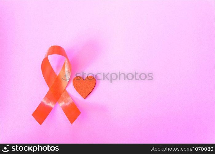 Red Ribbon Support HIV, AIDS on pink background and copy space for use