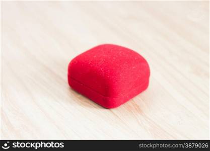 Red ring box on wooden background, stock photo