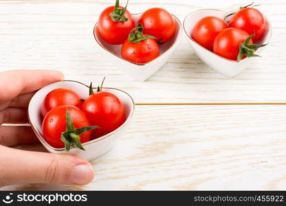 Red ripe cherry tomatos tomatos in heart shaped bowl