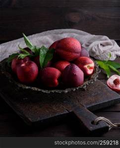 red ripe peaches nectarine in an iron plate, close up