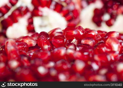 Red ripe pomegranate grains are the closest together in the open started fruit, healthy fruits. Red ripe pomegranate grains