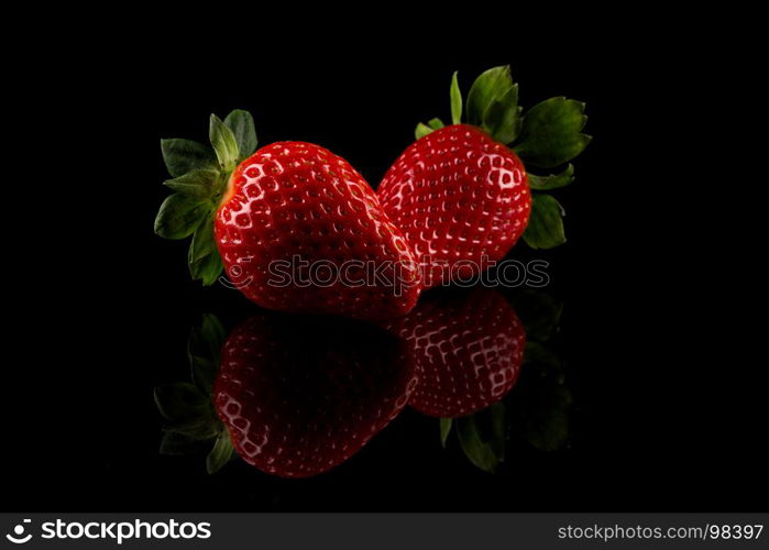 Red ripe strawberry fruits on a dark background