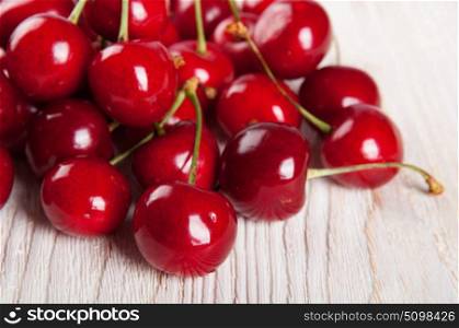 Red ripe sweet cherry on a wooden background