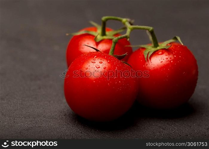 Red ripe tomatoes on a dark background, close up, copy space. Red ripe tomatoes on a dark background, close up, top view, copy space