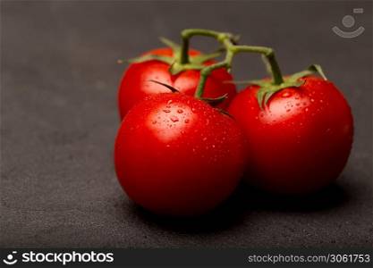 Red ripe tomatoes on a dark background, close up, copy space. Red ripe tomatoes on a dark background, close up, top view, copy space