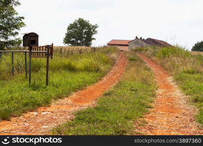 Red road bringing to house, with mailbox on the left, horizontal image