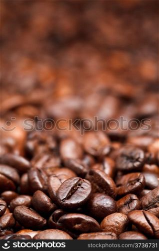 red roasted coffee beans background with focus foreground