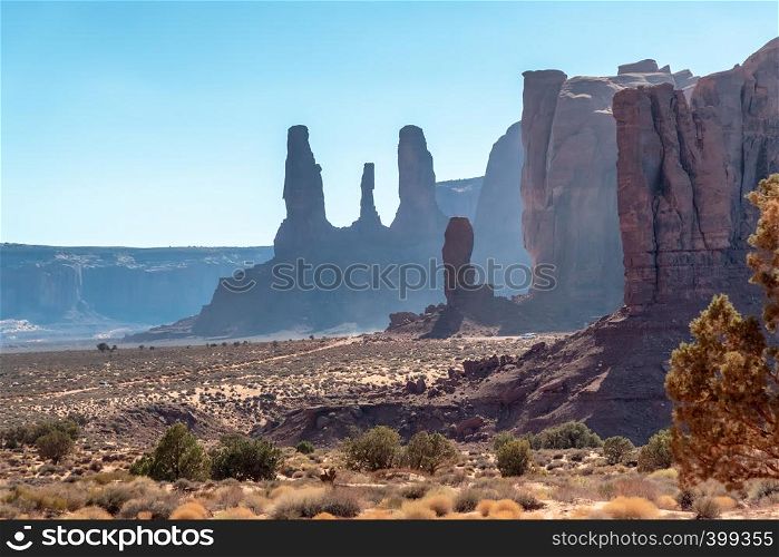 Red rocks of Monument Valley on a clear summer day. The Three Sisters at dusk.