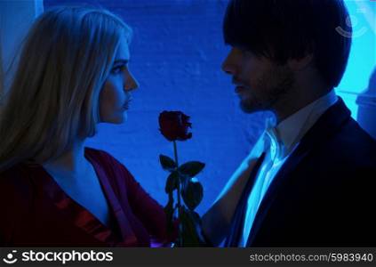 Red rose between couple in love
