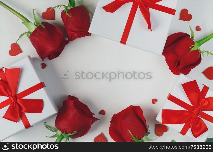 Red rose flowers gifts and red hearts composition on white background top view with copy space. Valentine&rsquo;s day, birthday, wedding, Mother&rsquo;s day concept. Copy space. Red roses hearts card