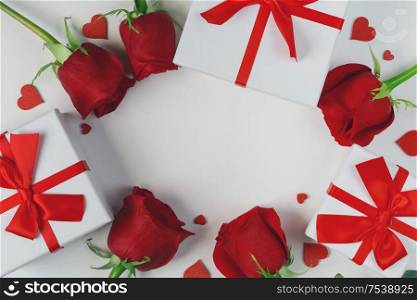 Red rose flowers gifts and red hearts composition on white background top view with copy space. Valentine&rsquo;s day, birthday, wedding, Mother&rsquo;s day concept. Copy space. Red roses hearts card