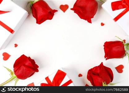 Red rose flowers hearts and gifts composition on white background top view with copy space. Valentine’s day, birthday, wedding, Mother’s day concept. Copy space. Red roses hearts gifts card