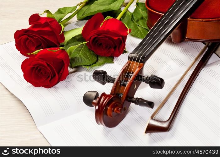 Red roses and a violin. Red roses and a violin on the table