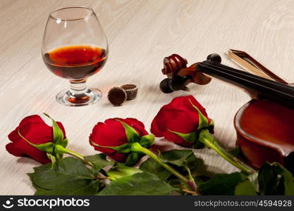 Red roses and a violin. Red roses and a violin on the table