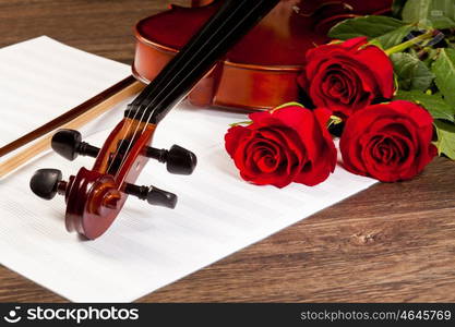 Red roses and a violin. Red roses and a violin on the table