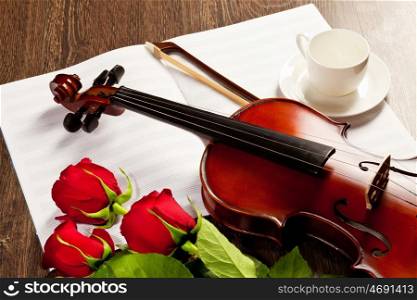 Red roses and a violin. Red roses and a violin on the table