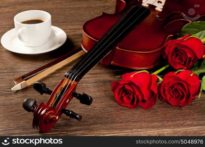 Red roses and a violin. Red roses and a violin on the table