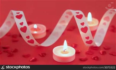 Red roses and chocolate candies with candles for Valentine&acute;s Day. Love and romance concept.