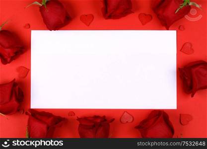 Red roses and red hearts composition and white card background top view with copy space. Valentine&rsquo;s day, birthday, wedding, Mother&rsquo;s day concept. Copy space. Red roses hearts and blank card