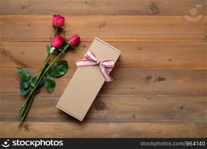 Red roses and vintage gift box on vintage wood background, with copy space, valentine's day background, top view