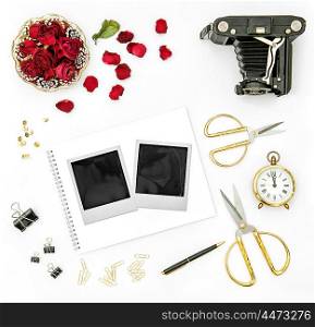 Red roses flower petals, vintage camera and photo frames. Flat lay background