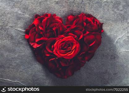 Red roses in heart shape on grey stone background. Valentine&rsquo;s Day. Symbol of love and romance.. Red roses in heart shape